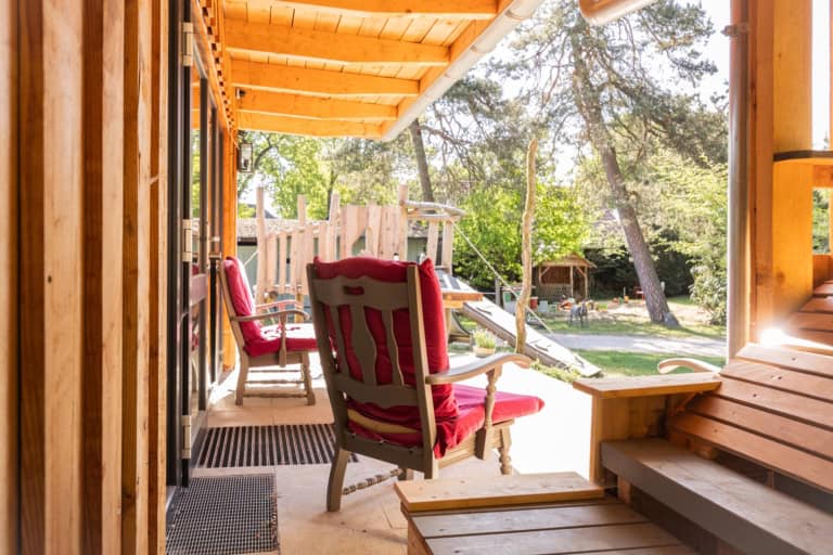 Gemütlicher Schattenplatz auf der Veranda mit Blick auf den Sandspielplatz auf Ferienhof Drewes in Ollsen/Lüneburger Heide