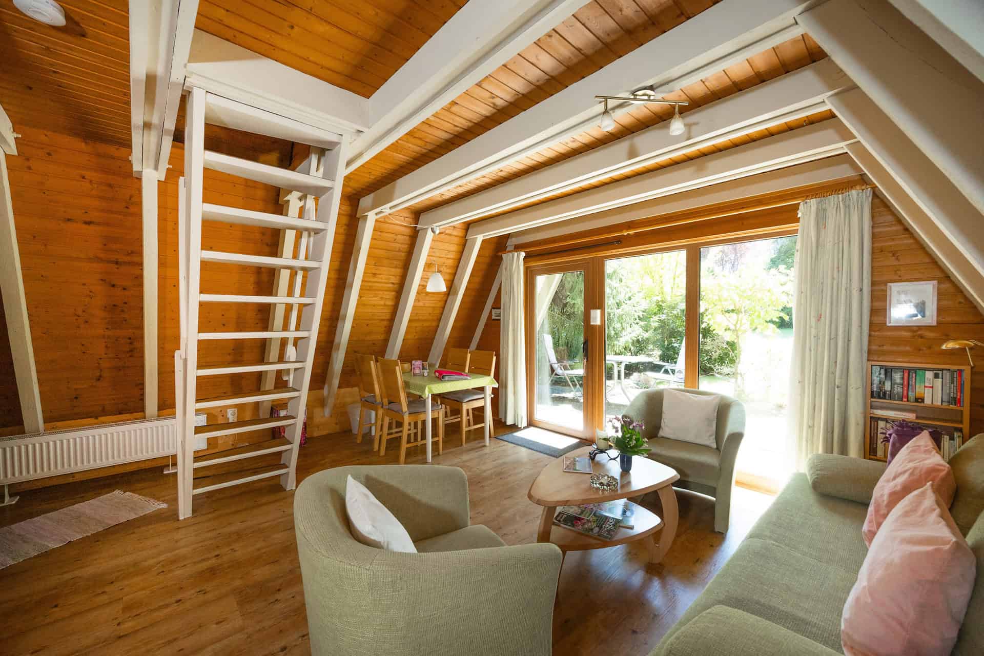 Alle Ferienhäuser haben einen gemütlichen Wohnraum mit Essecke und Blick in Grüne