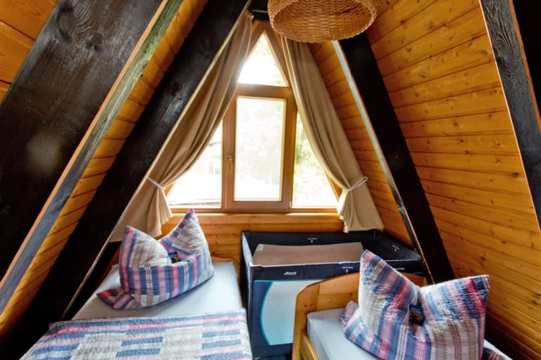 Schlafzimmer im Giebel mit Blick ins Grüne Hier ist auch Platz für ein Kinderbett: Ferienhäuser auf Ferienhof Drewes: Innenansichten Schlafzimmer mit je zwei Betten 90 x 200 cm (offenes Fußende)