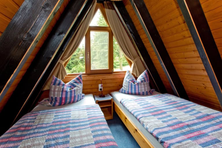 Schlafzimmer im Giebel mit Blick ins Grüne Ferienhäuser auf Ferienhof Drewes: Innenansichten Schlafzimmer mit je zwei Betten 90 x 200 cm (offenes Fußende)