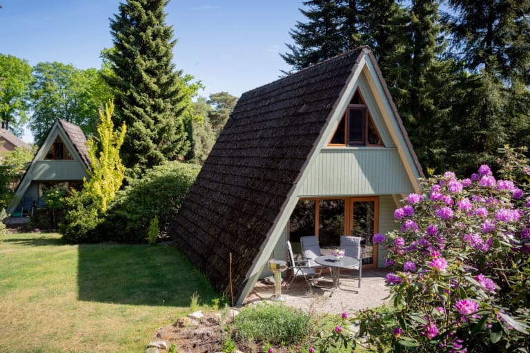 Südansicht von Ferienhaus 1 mit teilüberdachter Terrasse, Gartenmöbeln und Grill auf dem Ferienhof Drewes in Ollsen