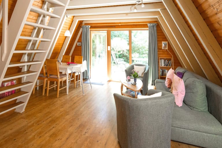 Ferienhäuser auf Ferienhof Drewes/Ollsen Die Sonne scheint ins Wohnzimmer, großes Fenster mit Blick ins Grüne